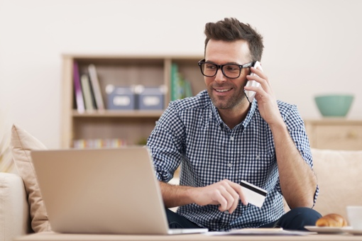 Un homme qui fait des opérations bancaires par téléphone