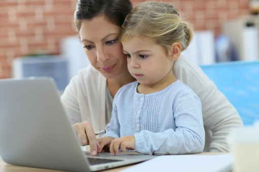 Une mère et sa fille utilisent un ordinateur à la maison